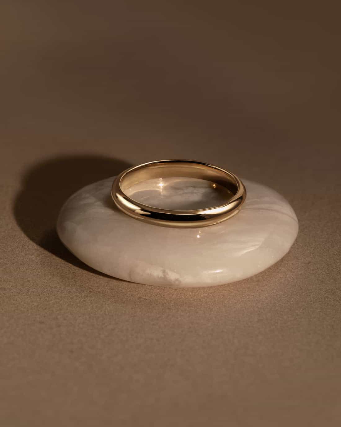 Or 18 carats poli reposant sur une pierre claire — matière de l'atelier Précieuse, Bordeaux